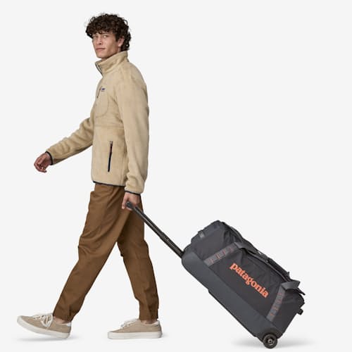 on model image of Black Hole Wheeled Duffel - 70L